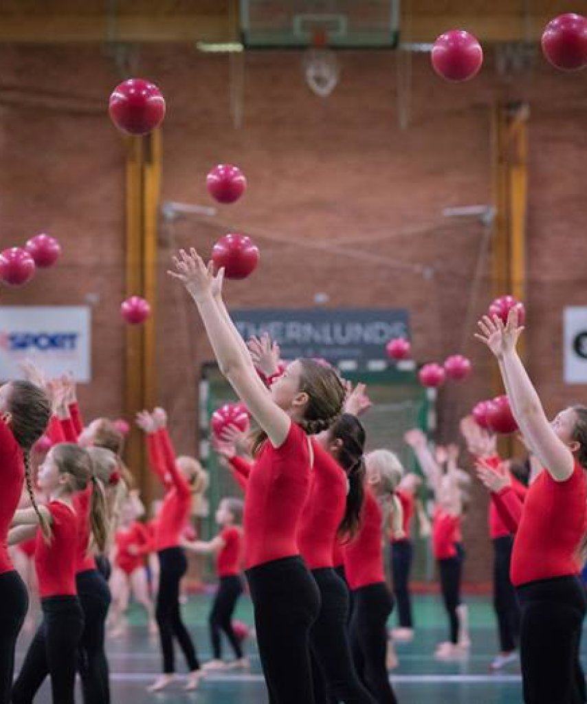 9-12 åringar som uppträder med röda bollar. 9-12 års grupper finns på idlas gymnastik i Hässelby och Liljeholmen.