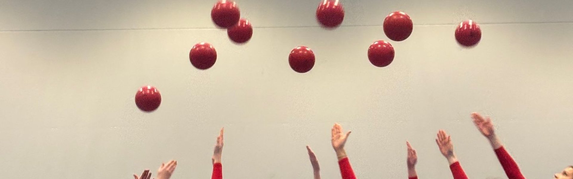 Tjejer med röda bollar. Gymnastikuppvisning.